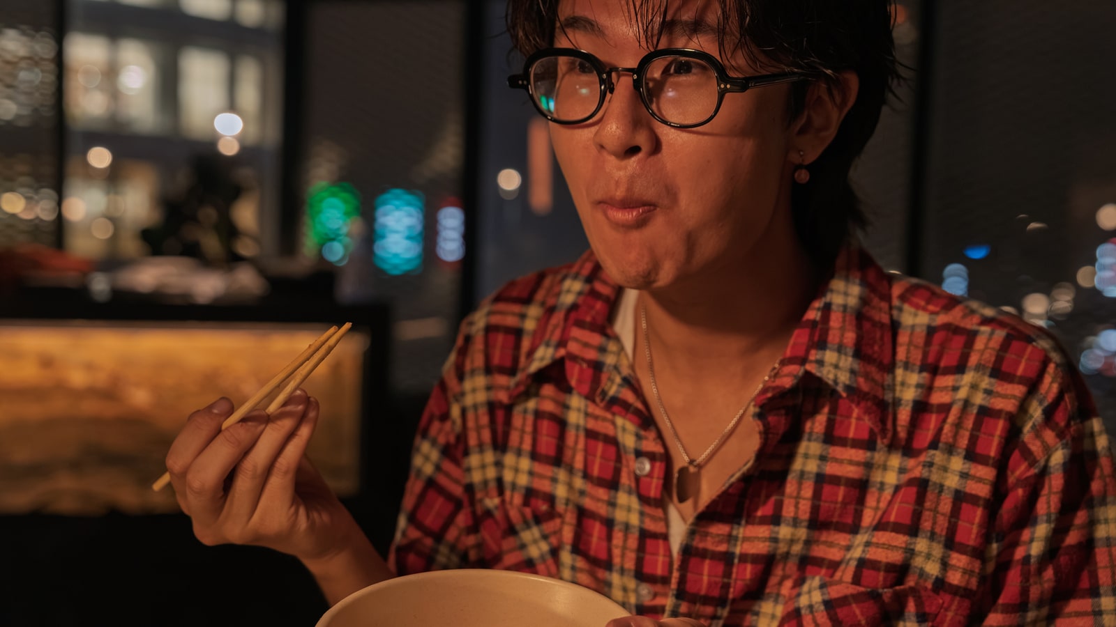 器と箸を手に、ミカさんの芋たきを味わう様子